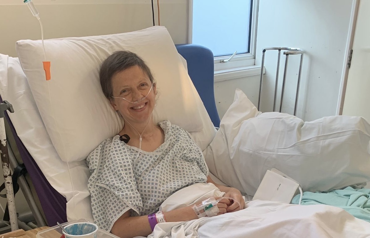 Founder smiling in a hospital bed during treatment
